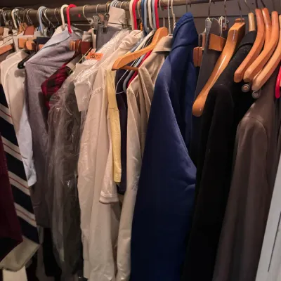 Sale Photo Thumbnail #43: Closet filled with assorted men's clothing on hangers, including suit jackets, dress shirts, and outerwear.