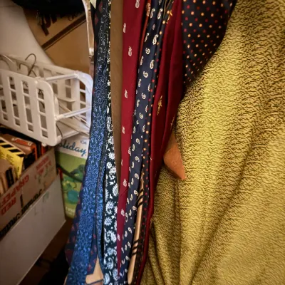 Sale Photo Thumbnail #75: Collection of vintage neckties hanging on a wooden rack, featuring various paisley, geometric, and novelty patterns.