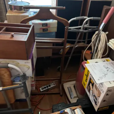 Sale Photo Thumbnail #138: Cluttered household assortment featuring a wooden valet stand, vintage speakers, audio equipment, medical walkers, and household goods.
