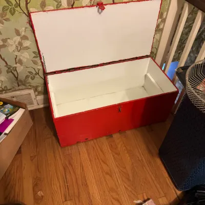 Sale Photo Thumbnail #35: Hand-painted wooden storage chest featuring a bright red exterior and a white-painted interior. The lid opens on hinges to reveal a spacious main compartment with minor wear throughout.