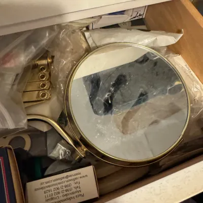 Sale Photo Thumbnail #33: Wall-mounted accordion brass makeup mirror stored inside a drawer among assorted small items.