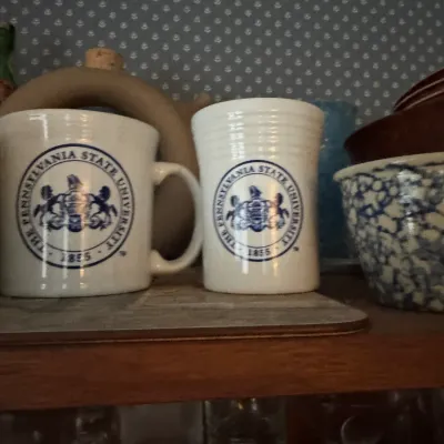 Sale Photo Thumbnail #114: Vintage ceramic mug and cup featuring blue Penn State University seal graphics.