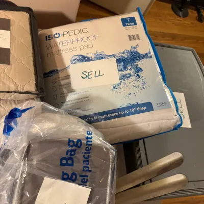 Sale Photo Thumbnail #95: Iso-Pedic twin waterproof mattress pad in original packaging alongside other bedding accessories.