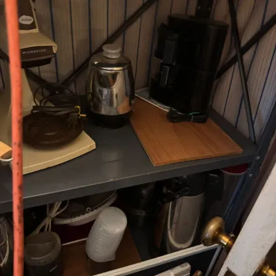 Sale Photo Thumbnail #74: Metal shelving unit holding various small kitchen appliances, including a vintage Sunbeam Mixmaster and a stainless steel percolator.