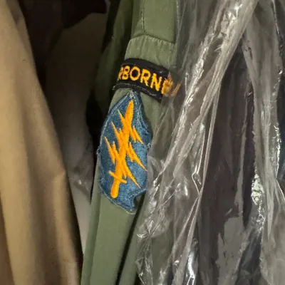 Sale Photo Thumbnail #6: Vintage military olive drab uniform sleeve featuring an Airborne tab and a US Army Special Forces insignia patch.