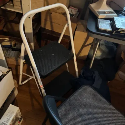 Sale Photo Thumbnail #71: White metal two-step folding stool with non-slip black treads, surrounded by office and storage items.