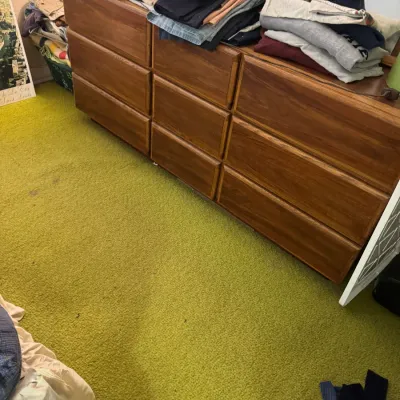 Sale Photo Thumbnail #39: Large wooden multi-drawer dresser loaded with stacks of folded clothing.