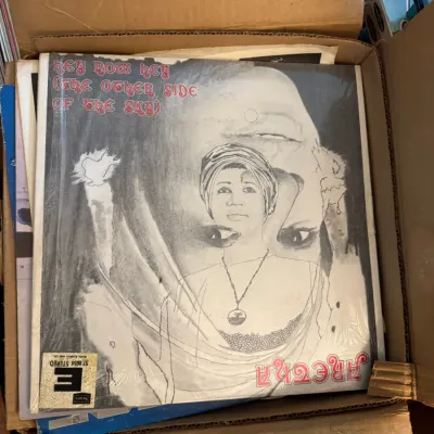 Sale Photo Thumbnail #24: Aretha Franklin's 1974 vinyl LP 'Hey Now Hey (The Other Side of the Sky)' resting inside a cardboard storage box with other records.