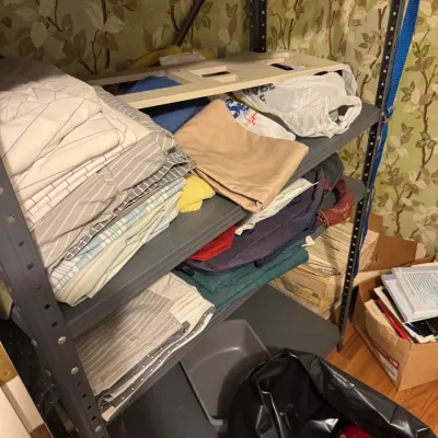 Sale Photo Thumbnail #34: Metal shelving unit holding stacked linens, fabrics, bags, and household accessories.