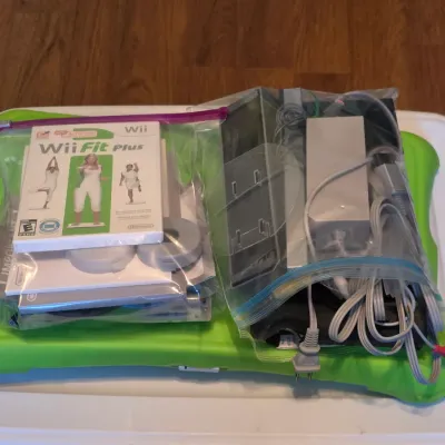 Nintendo Wii Balance Board in a green silicone cover, bundled with a Wii console, power adapter, cables, and Wii Fit Plus video game in...