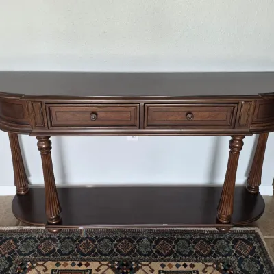 Traditional dark wood console table with fluted legs, two drawers, and a lower display shelf.