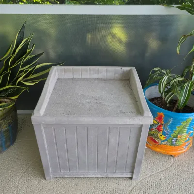 Suncast light gray resin outdoor side table or deck box with beadboard-style side panels.