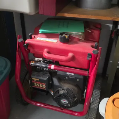 WheelHouse 5550 portable generator with a red tubular frame, Briggs & Stratton engine, and attached wheels.