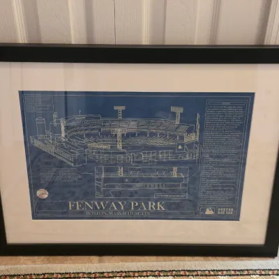 Framed Fenway Park architectural schematic print featuring historical details and stadium specifications, mounted in a black frame with...