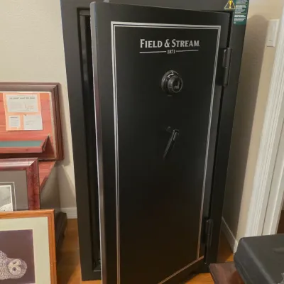 Large black Field & Stream gun safe featuring a combination lock, drop lever handle, and silver pinstriping accent.