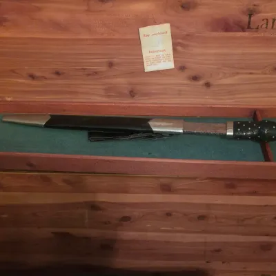 Scottish dirk with a carved hilt and sheath, stored inside the felt-lined tray of a vintage Lane cedar chest.