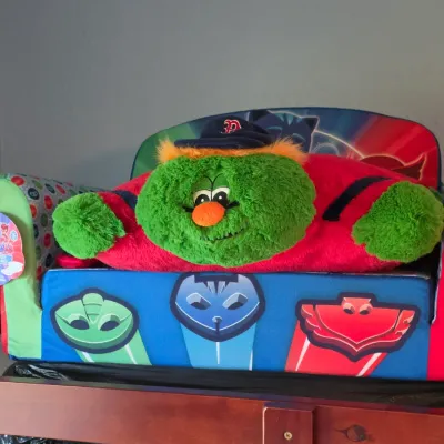 PJ Masks toddler foam flip-open sofa chair with tag attached, holding a plush Boston Red Sox Wally the Green Monster pillow pal.
