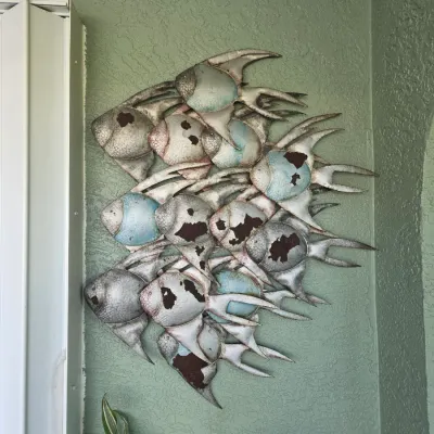 Large metal school of angelfish wall art featuring a distressed, weathered finish with light blue and silver painted accents.