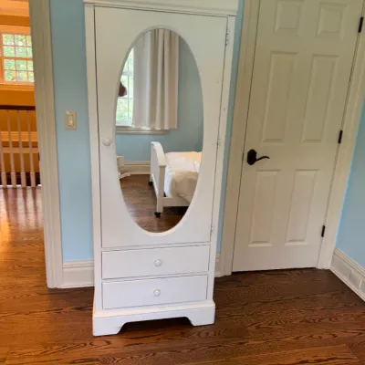 Sale Photo Thumbnail #154: White painted wooden armoire featuring an oval full-length mirror door and two lower drawers.