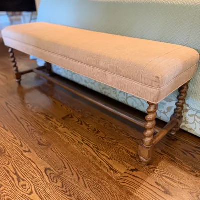 Sale Photo Thumbnail #85: Traditional end-of-bed bench with a beige upholstered seat and barley twist carved wooden legs.