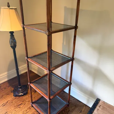 Sale Photo Thumbnail #42: Faux bamboo five-tier etagere shelf with woven cane inset tiers, accompanied by a traditional floor lamp.