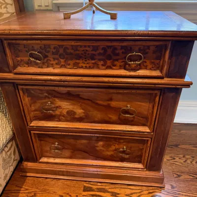 Sale Photo Thumbnail #81: Traditional wooden three-drawer nightstand featuring a pierced scrollwork accent on the top drawer and bail handles.