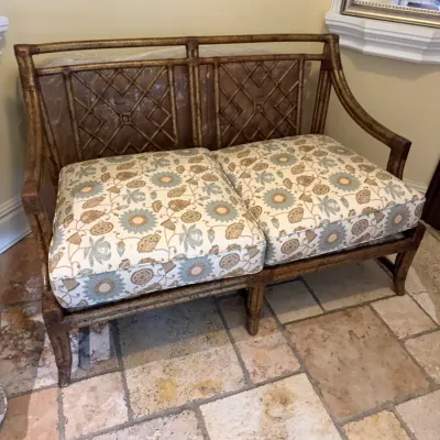 Sale Photo Thumbnail #198: Faux-bamboo bench or loveseat with a gilt finish, featuring lattice-back detail and upholstered floral cushions.