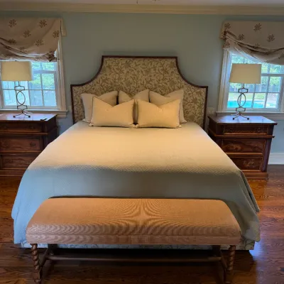 Sale Photo Thumbnail #78: Traditional master bedroom suit featuring an upholstered patterned headboard bed, a pair of wooden nightstands with brass lamps, and an upholstered end-of-bed bench.