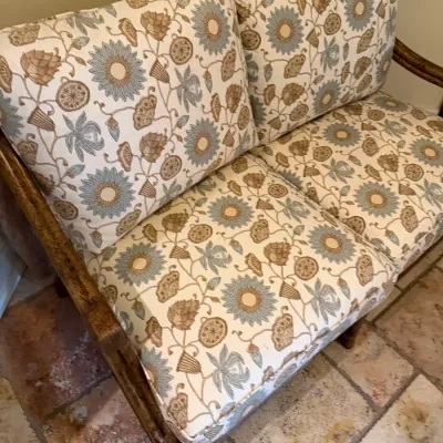 Sale Photo Thumbnail #201: Two-seat loveseat featuring a distressed wooden frame and plush cushions in a muted floral and botanical pattern.
