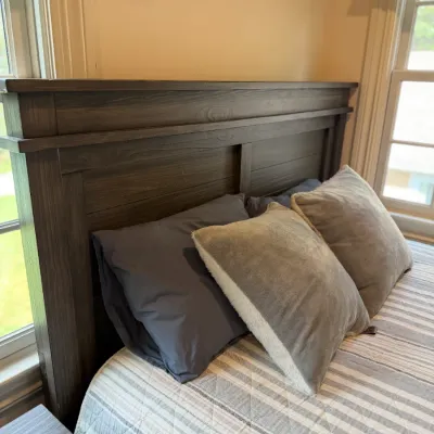 Sale Photo Thumbnail #147: Rustic modern dark grey wooden headboard on a bed dressed with neutral bedding and accent pillows.