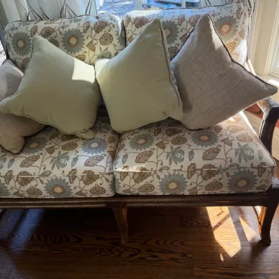 Sale Photo Thumbnail #66: Dark rattan loveseat featuring floral-patterned cushions in blue and beige tones, accompanied by four coordinating throw pillows.