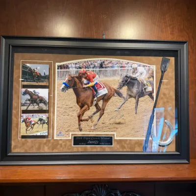 Sale Photo Thumbnail #48: Framed 2018 Triple Crown winner Justify memorabilia display, featuring photographs signed by jockey Mike Smith alongside a riding crop and horseshoe.