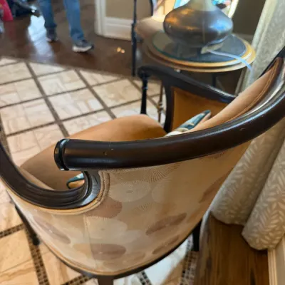 Sale Photo Thumbnail #59: Traditional barrel-back armchair with dark wood trim, pattern-upholstered outer back, and a plush gold seat cushion.