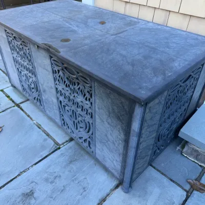 Sale Photo Thumbnail #17: Large outdoor patio storage deck box featuring decorative scrollwork side panels and a dark finish, showing light weathering.