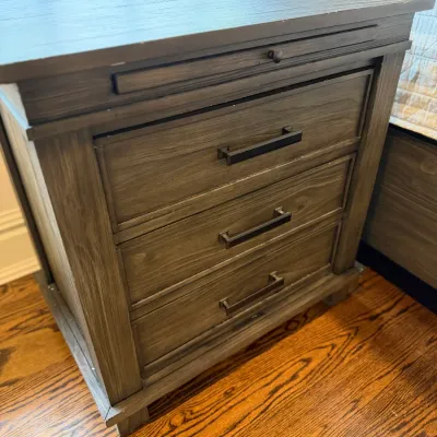 Sale Photo Thumbnail #146: Modern rustic wooden nightstand with a distressed grey finish, three drawers, dark metallic bar pulls, and a pull-out slide.