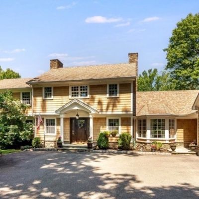 Sale Photo Thumbnail #2: Exterior view of a two-story cedar shingle-style house featuring a paved driveway and attached multi-car garage.