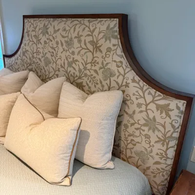Sale Photo Thumbnail #79: Upholstered king-size headboard with a dark wood frame and floral vine fabric, shown with coordinating decorative throw pillows and bedding.