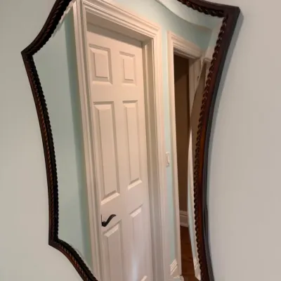 Sale Photo Thumbnail #160: Asymmetrical wall mirror in a dark wood frame with twisted rope detailing, featuring beveled edge glass.