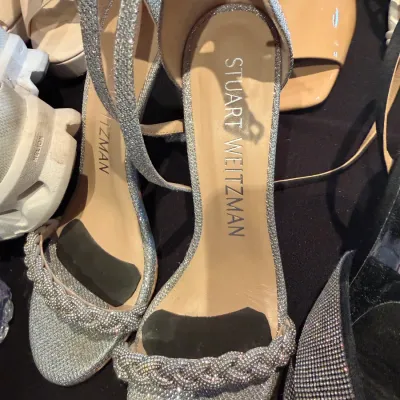 Sale Photo Thumbnail #105: Pair of Stuart Weitzman silver glitter ankle-strap heeled sandals featuring a braided crystal-embellished front strap.