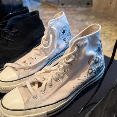 Sale Photo Thumbnail #100: Pair of cream Converse Chuck Taylor All Star high-top sneakers with floral graphic details.