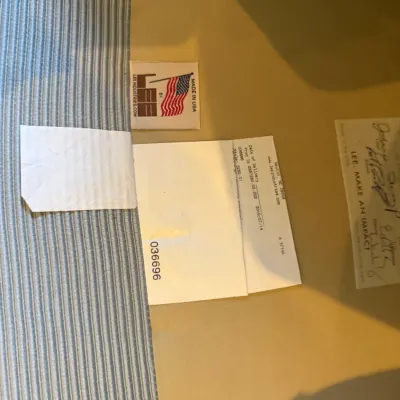 Sale Photo Thumbnail #29: Manufacturer tags and inspection labels under the cushion of an upholstered Lee Industries chair, dated 2010.