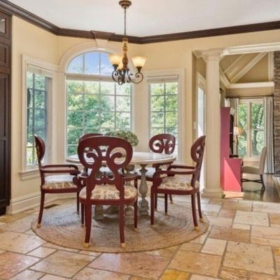 Sale Photo Thumbnail #9: Dining set including a pedestal table and five reddish-brown wooden chairs with upholstered seats, set on a round braided rug.