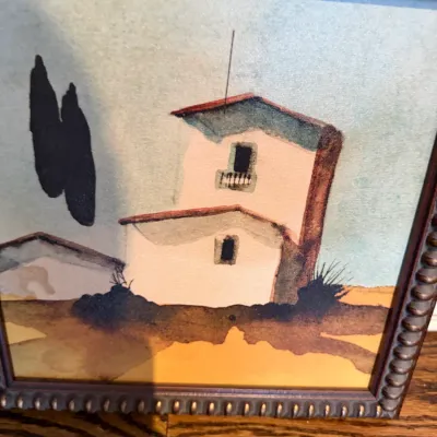 Sale Photo Thumbnail #116: Framed original watercolor painting depicting a Southwestern or Mediterranean style building with cypress trees, presented in a beaded dark wooden frame.