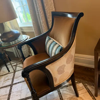 Sale Photo Thumbnail #57: Traditional dark wood accent armchair featuring brown velvet interior upholstery, a patterned cream fabric exterior back, and a small striped lumbar pillow.