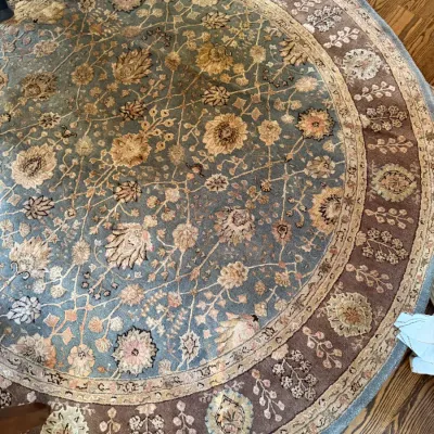 Sale Photo Thumbnail #76: Large round wool area rug featuring a muted blue and beige traditional botanical floral design with decorative borders.