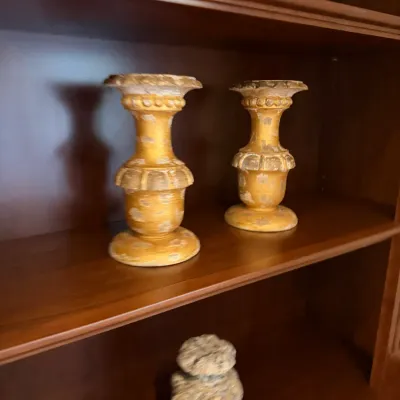 Sale Photo Thumbnail #52: Pair of vintage distressed gold-painted carved wooden candleholders displayed on a wooden shelf.