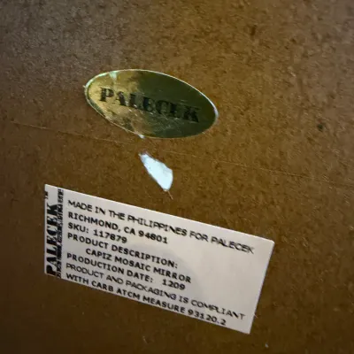 Sale Photo Thumbnail #202: Manufacturer labels on the back of a Palecek Capiz Mosaic Mirror, made in the Philippines.