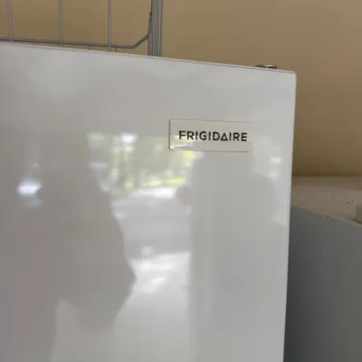 Sale Photo Thumbnail #131: White Frigidaire mini fridge or upright freezer, featuring a glossy front panel with brand logo.