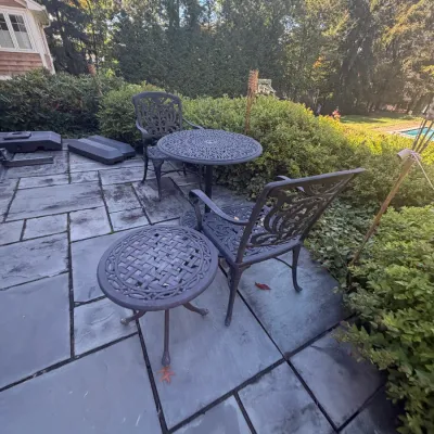 Sale Photo Thumbnail #25: Cast aluminum outdoor patio set including two armchairs with ornate scrollwork backs, a small round Bistro table, and a matching accent table.