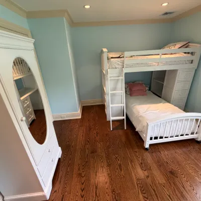 Sale Photo Thumbnail #149: White painted wooden bedroom furniture set featuring a loft bed unit with built-in desk and drawers, a lower single bed, and a matching armoire with an oval mirror.